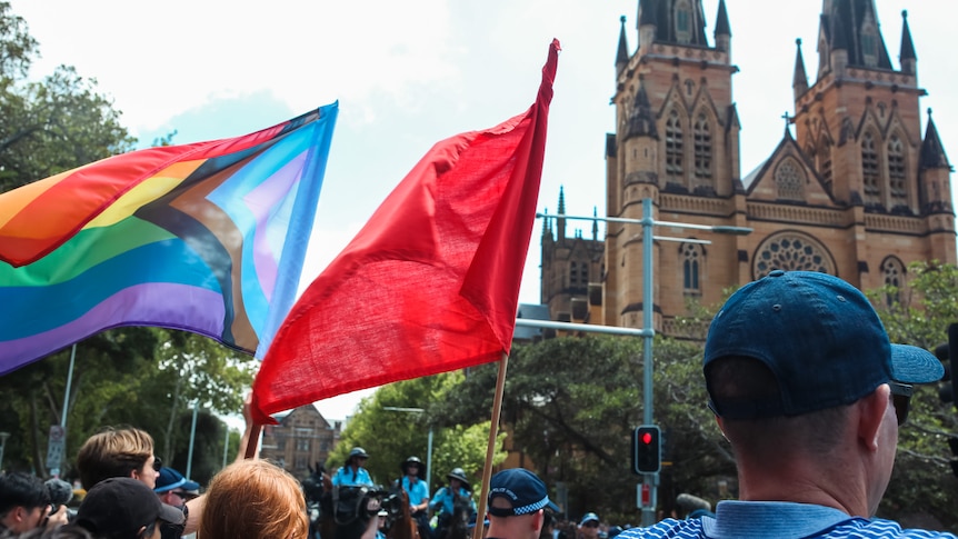 Protesters waving rainbow flag near Sydney's St Mary's Cathedral