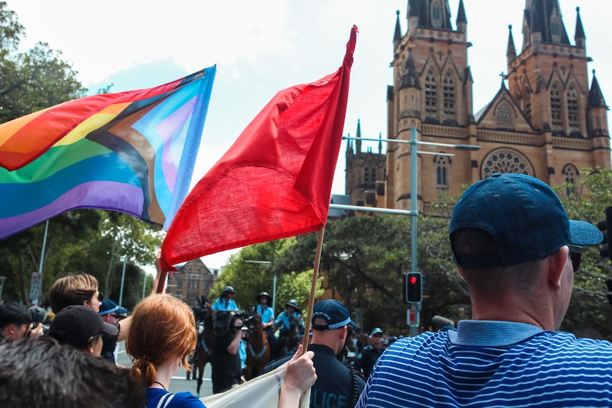 Protesters waving rainbow flag near Sydney's St Mary's Cathedral
