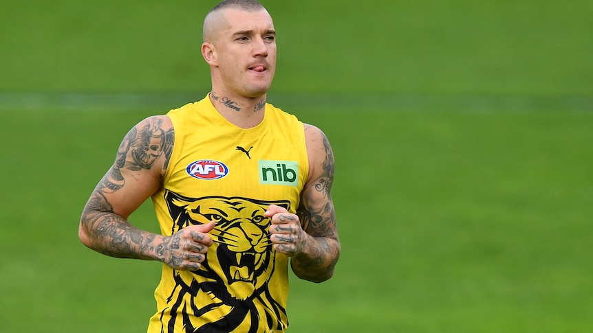 Dustin Martin purses his lips and sticks his tongue out while running at a training session