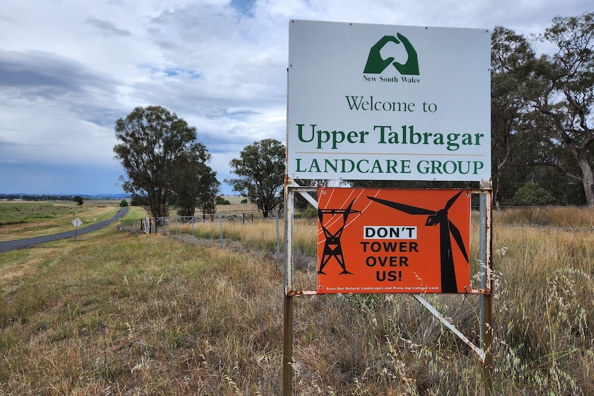 Sign that states "welcome to Upper Talbragar landcare group" with another sign below that states "don't tower over us"