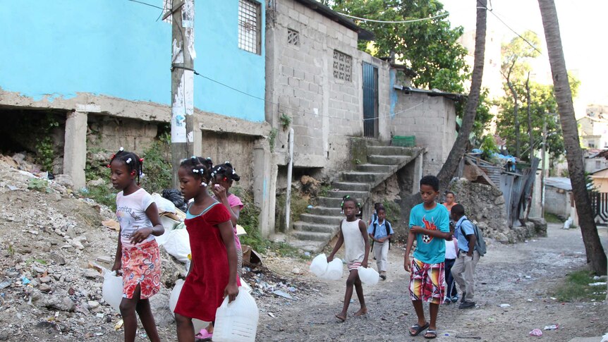 Children in a low-income neighbourhood carry containers for water