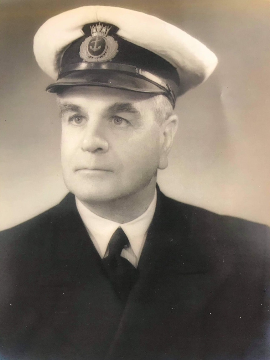 A black and white portrait of a middle aged man in a Navy captain's uniform.