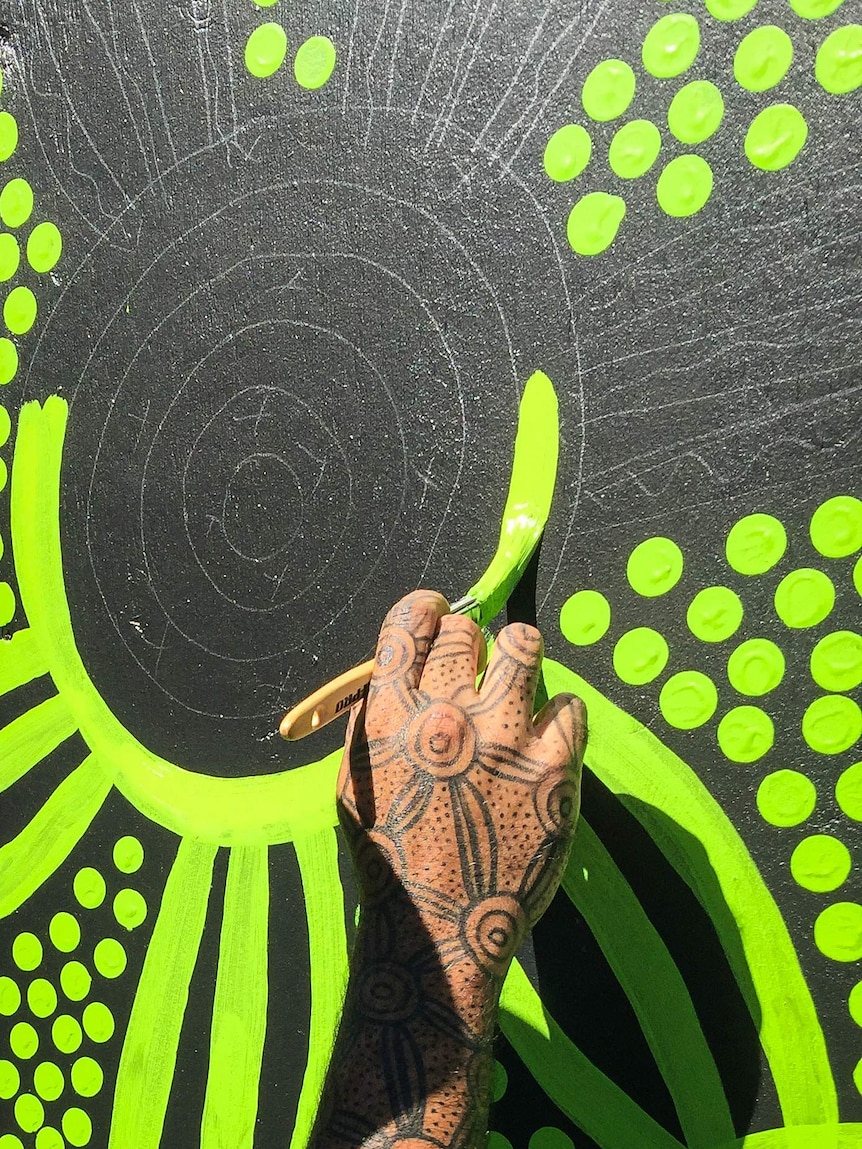 Hand painting dots on a wall.