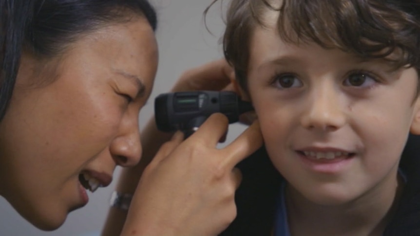 Doctor looking inside a boy's ear