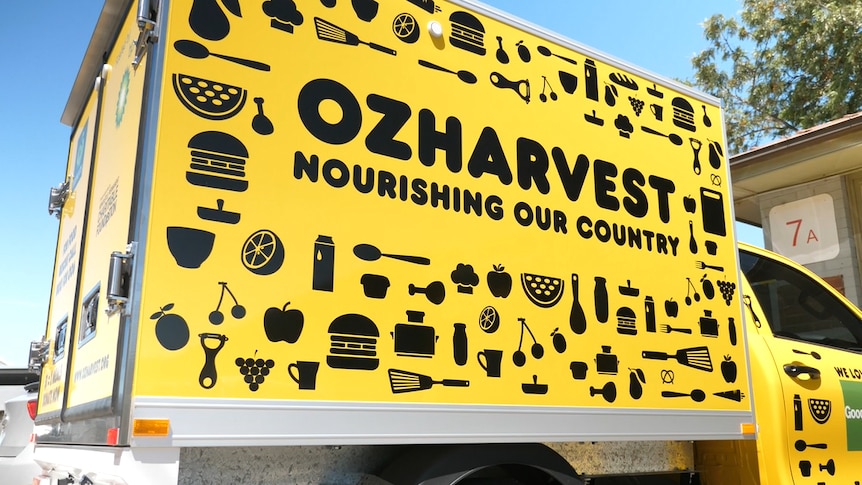 a bright yellow ozharvest truck parked at its warehouse