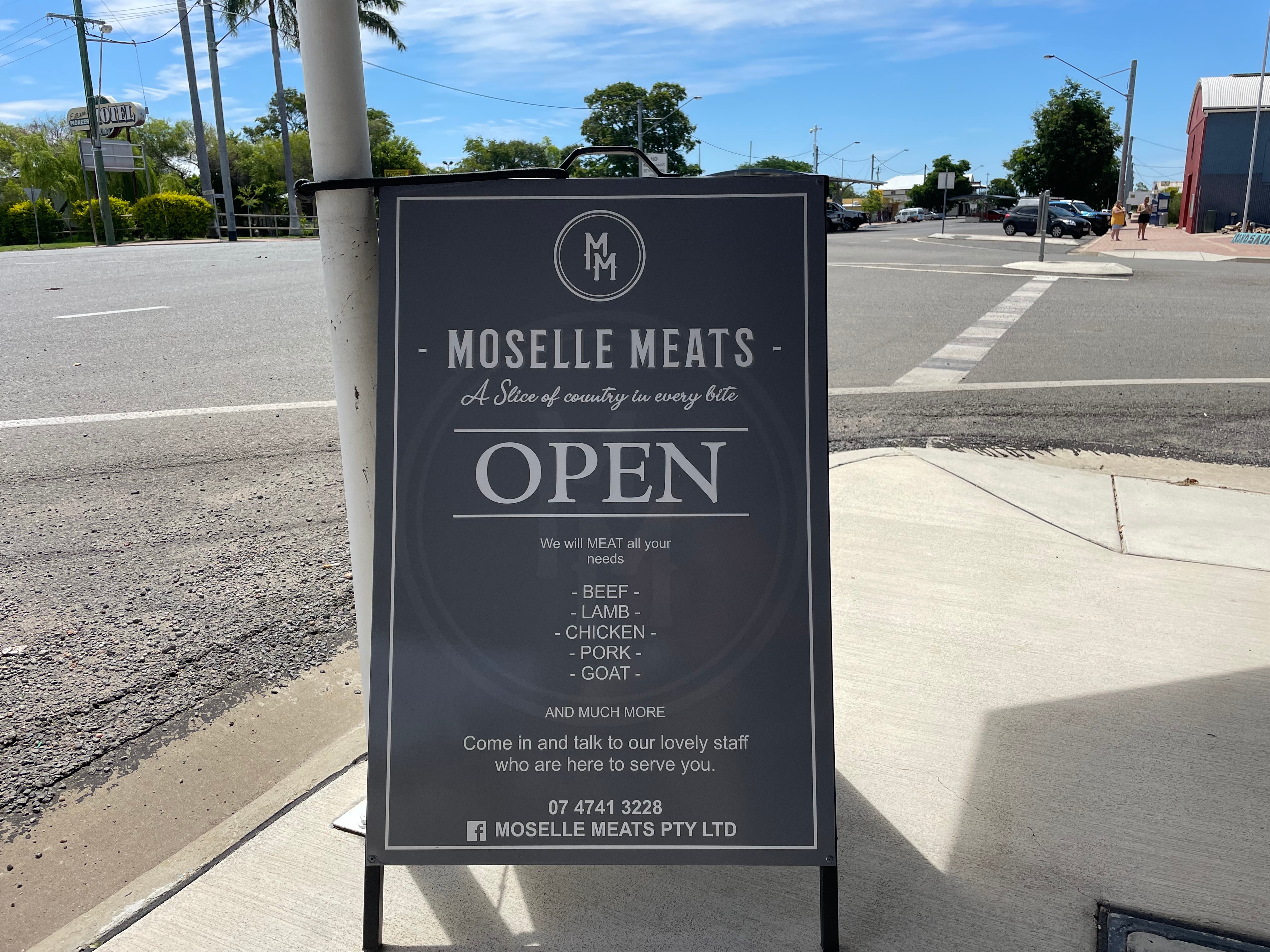 Butcher shop sign on corner of road. 