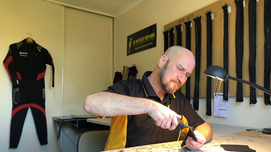 Wetsuit maker Ken Brain at work.