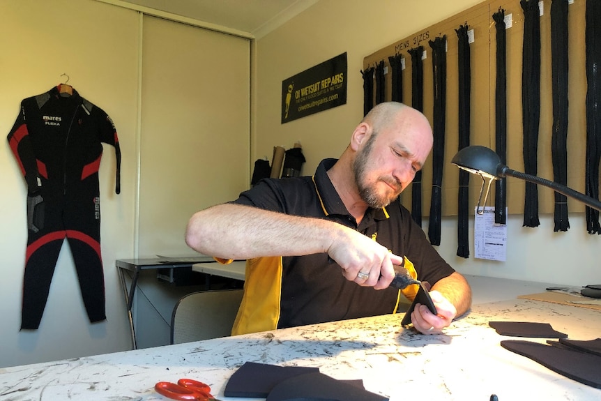 Wetsuit maker Ken Brain at work.