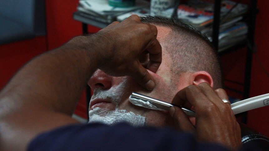 Shaving a man's face with a razor