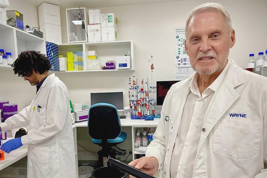 Man in science lab smiling at camera