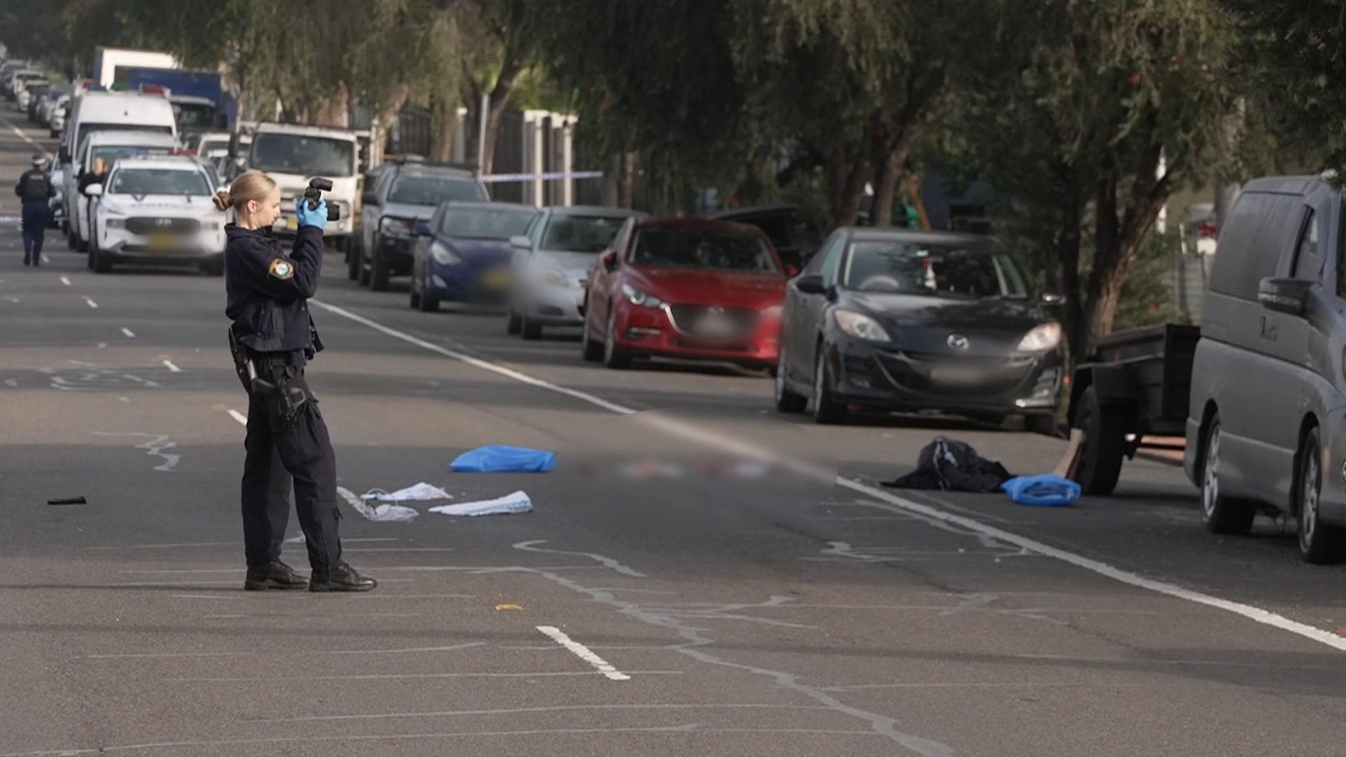 a forensic police officer takes pictures at a crime scene
