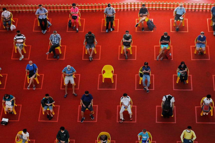 People watch an outdoor movie screening while socially distanced in Singapore