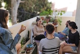 Adiel Cohney and other members of the Dror Israel collective relax on their balcony in Israel.