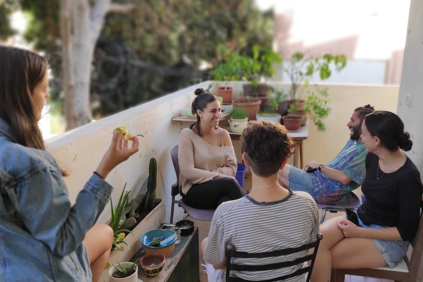 Adiel Cohney and other members of the Dror Israel collective relax on their balcony in Israel.