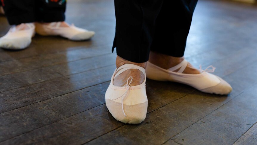 A close up shot of a women's feet in ballet slippers.