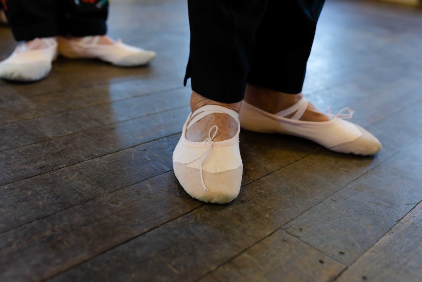 A close up shot of a women's feet in ballet slippers.