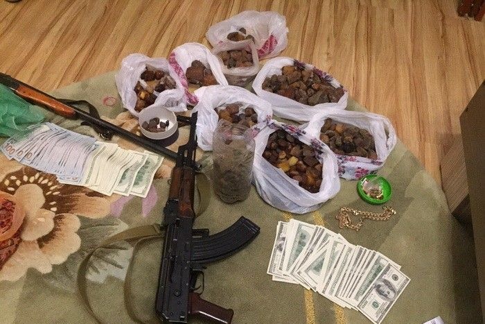 Bags of amber, guns and cash on a table.