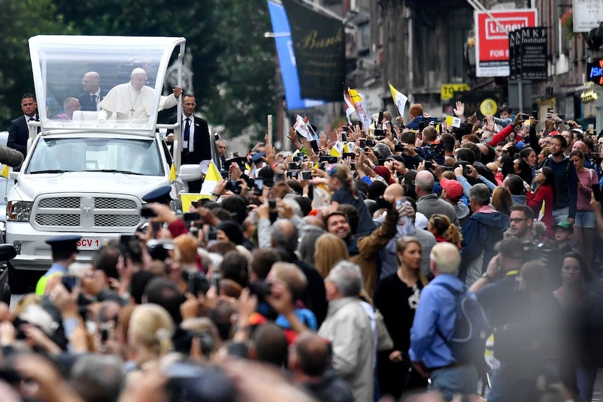 Pope Francis waves as he drives past well wishers during his visit in Dublin.