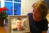 Cheryl Olver looks at a photo of her son Daren