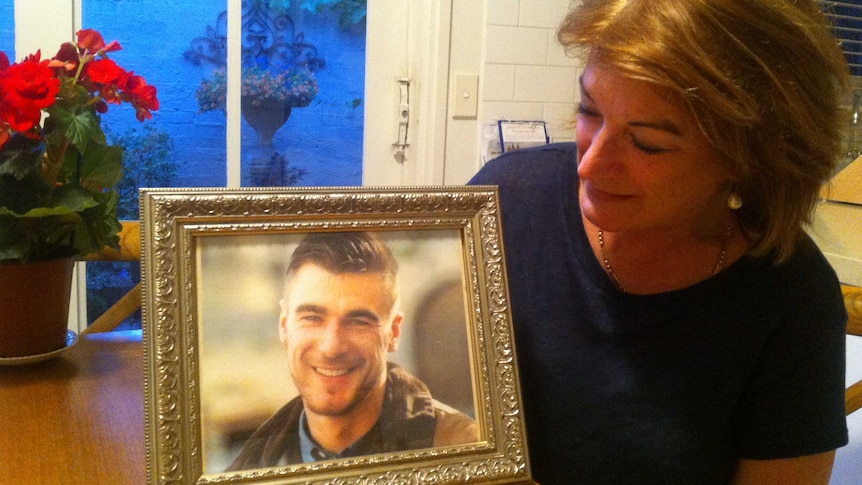 Cheryl Olver looks at a photo of her son Daren