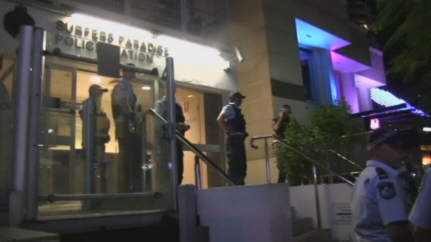 Officers protecting the entrance to Surfers Paradise police station after a riot this morning.