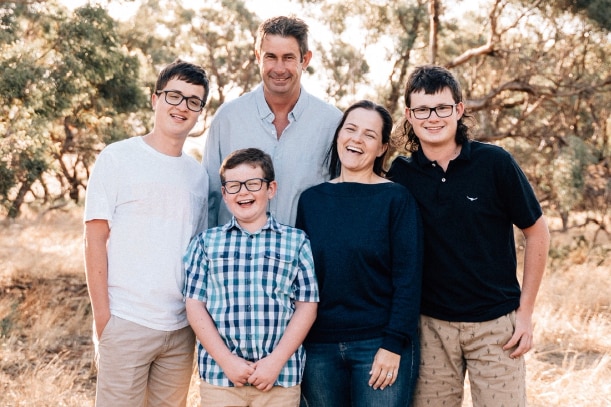 A fair-skinned family, Alex, Fiona and three sons laugh together at Thornby homestead.