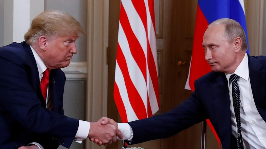 Trump and Putin shake hands in front of the russian and US flags