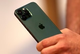 A person holds a green iPhone.