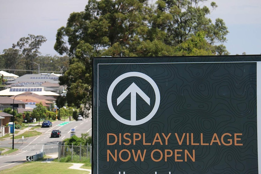 Display Village Now Open sign in street at a new housing estate.