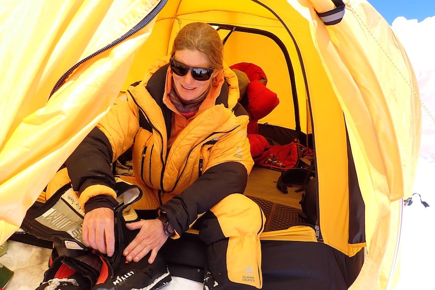 Mountaineer in yellow gear and sunglasses