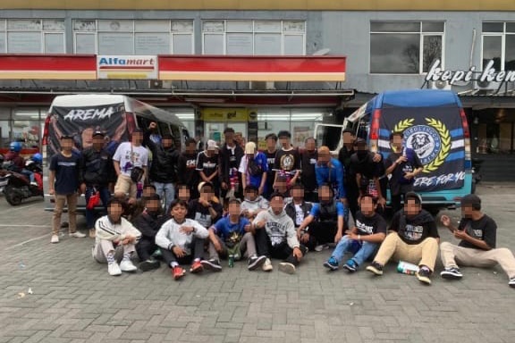 People posing in front of a store in Indonesia.