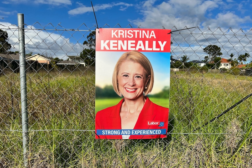 A sign of Kristina Keneally on a wire fence.