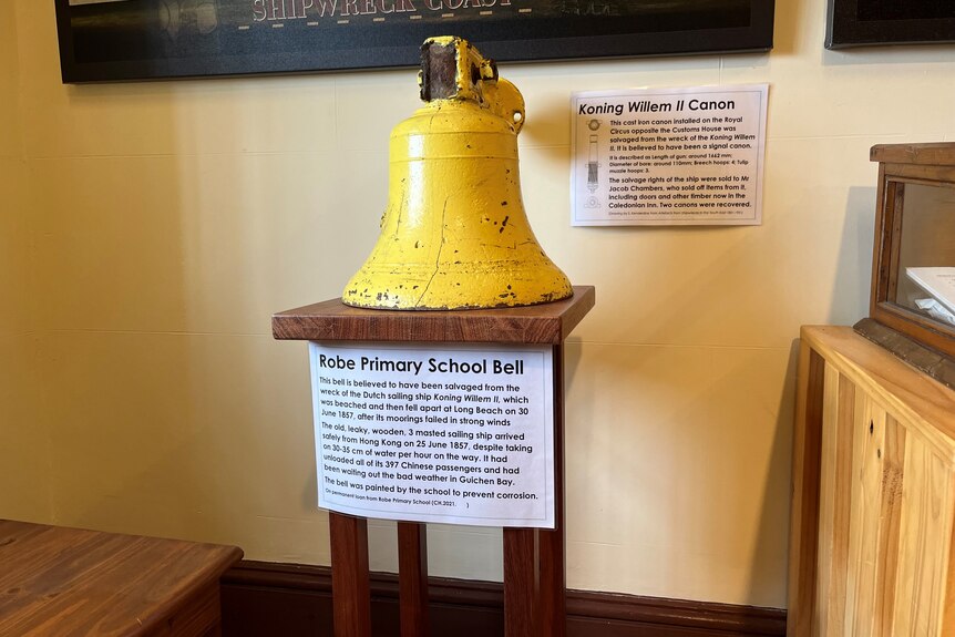 A yellow bell with placards around it
