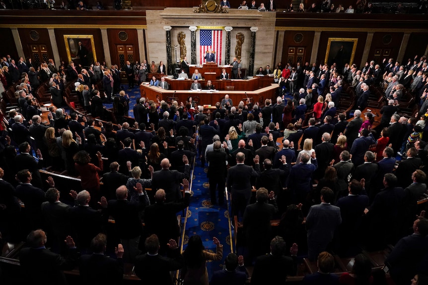 A full congress stands to be sworn in on the house floor. 