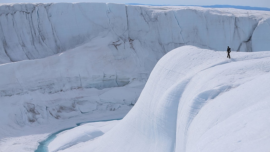 A person walks on a massive white ice sheet