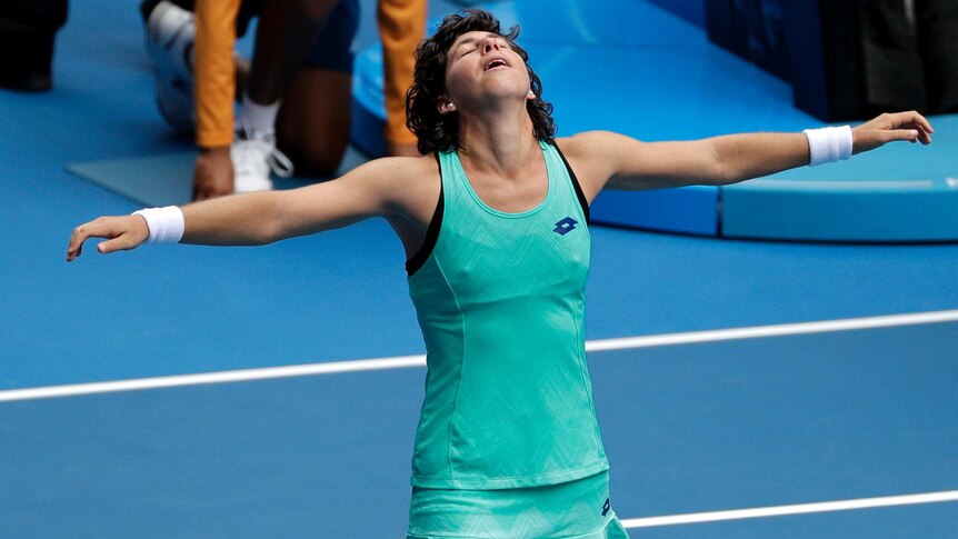 Carla Suarez Navarro with her arms spread out wide after winning her fourth-round match at the Australian Open.