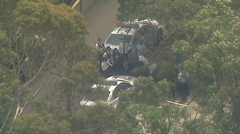 Police gathering around police cars