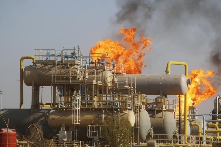 Flames emerge from a pipeline at the oil fields in Basra, southeast of Baghdad, Iraq