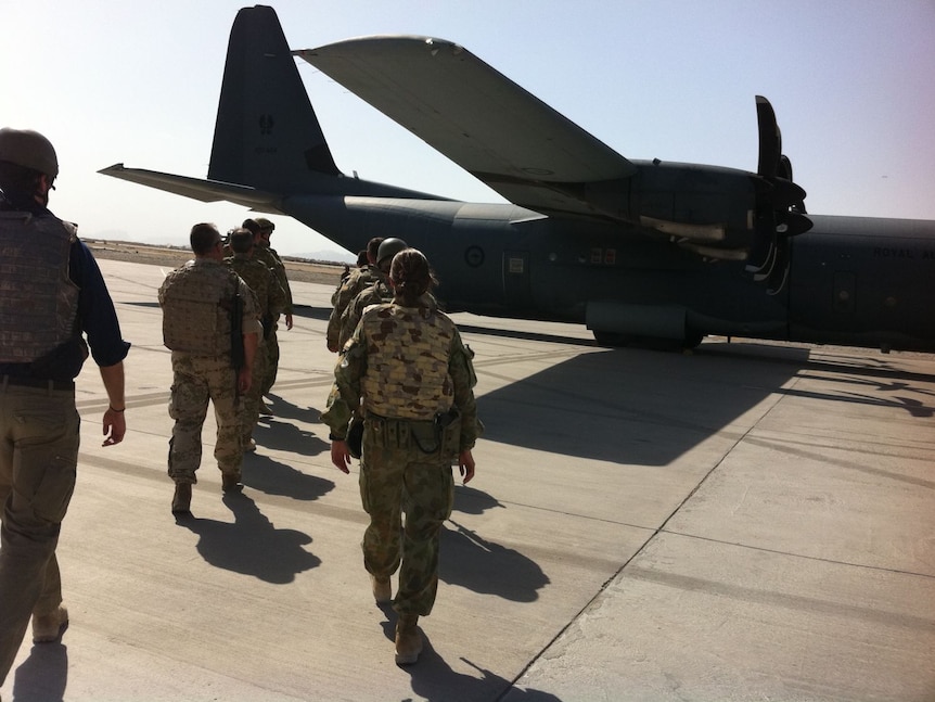 Australian troops and civilians boarding a C-130 Hercules in Afghanistan.