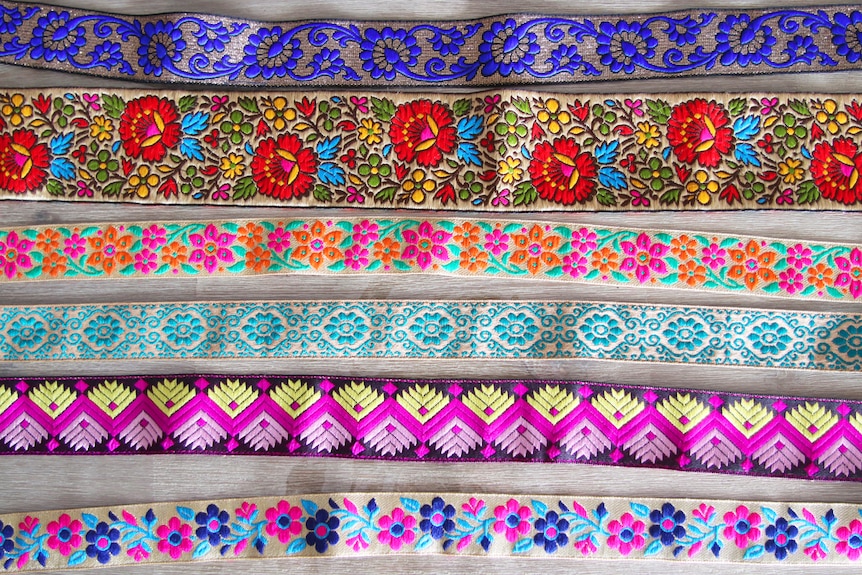 A variety of Gina Bajeel's colourful fabrics laid out on a table.