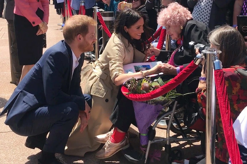 Prince Harry and Meghan with a woman in a wheelchair