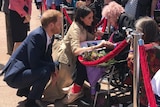 Prince Harry and Meghan with a woman in a wheelchair
