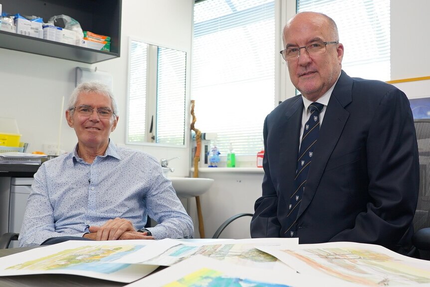 Clive Couperthwaite sitting with Professor Peter Silburn in an office.