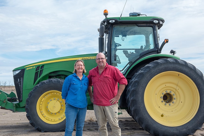 Rachel and Simon Walker stand in front of a planter.