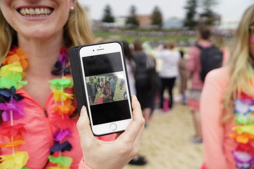 A woman holding up a phone