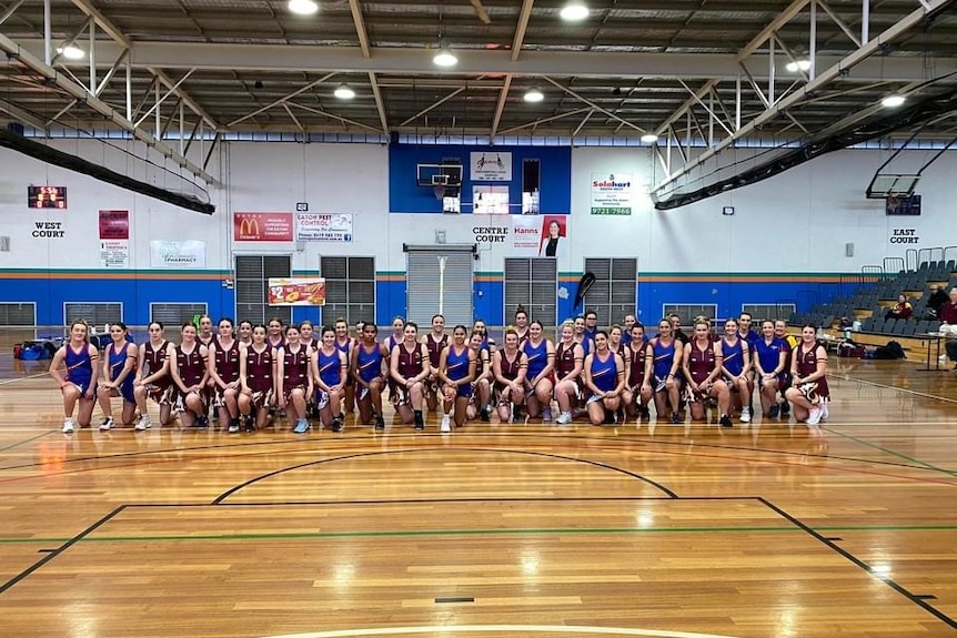 A shot of women kneeling in a gym