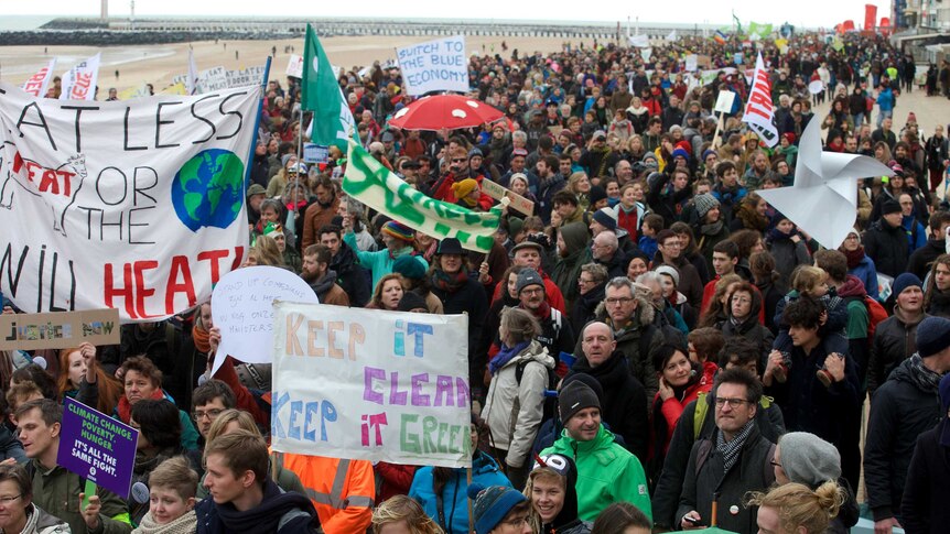 Climate change protestors march on a Belgian beach.