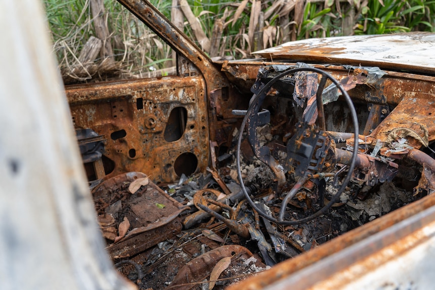 The inside of a burnt out vehicle. The interior is brown and black.