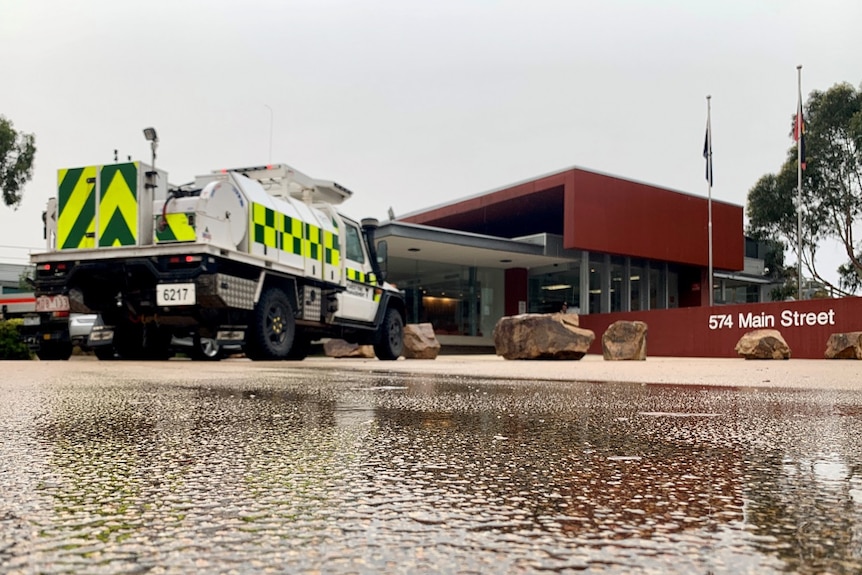 A CFA truck is parked in the Bairnsdale Incident Control Centre, as water runs along the driveway from rain.