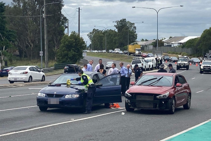 Police officers and cars at a crime scene where a man was shot by police in Brisbane's south-west.
